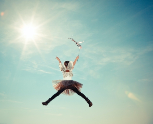 Image of child dressed as a fairy jumping in air.