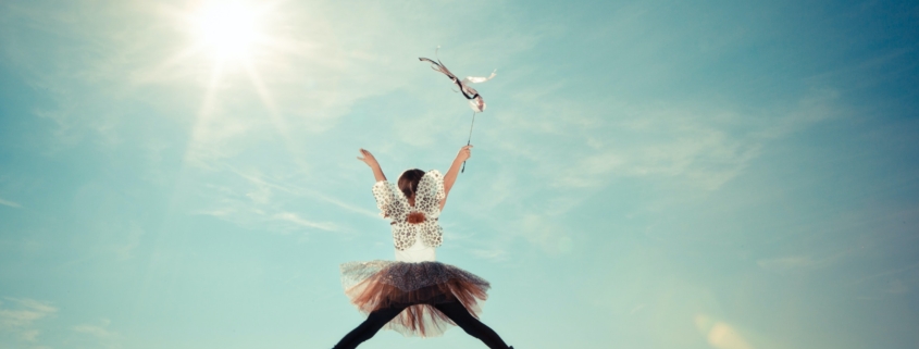 Image of child dressed as a fairy jumping in air.
