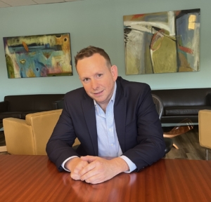 Matthew Clarke sitting at table in conference room.